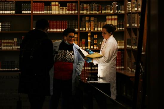 Las expositoras y autoras de la investigación revisando un libro en la Biblioteca